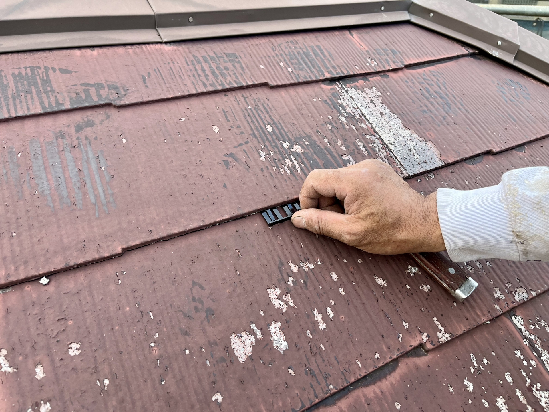 屋根塗装の縁切り作業とタスペーサー設置の様子